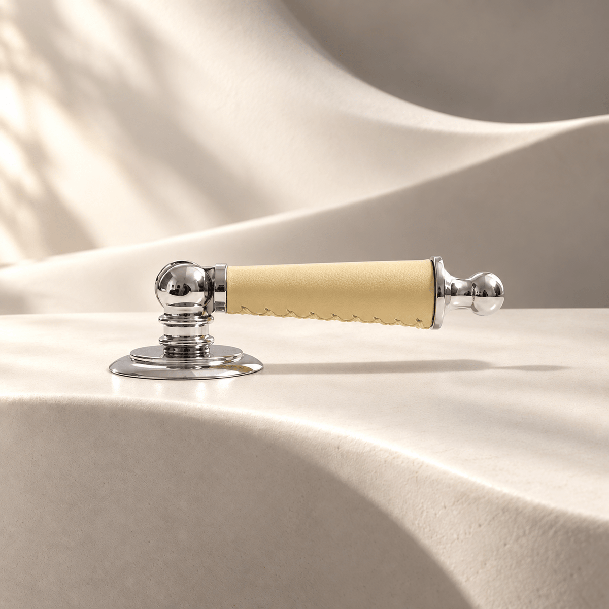 Silver-finish brass and light yellow leather drop pull on warm ivory stone