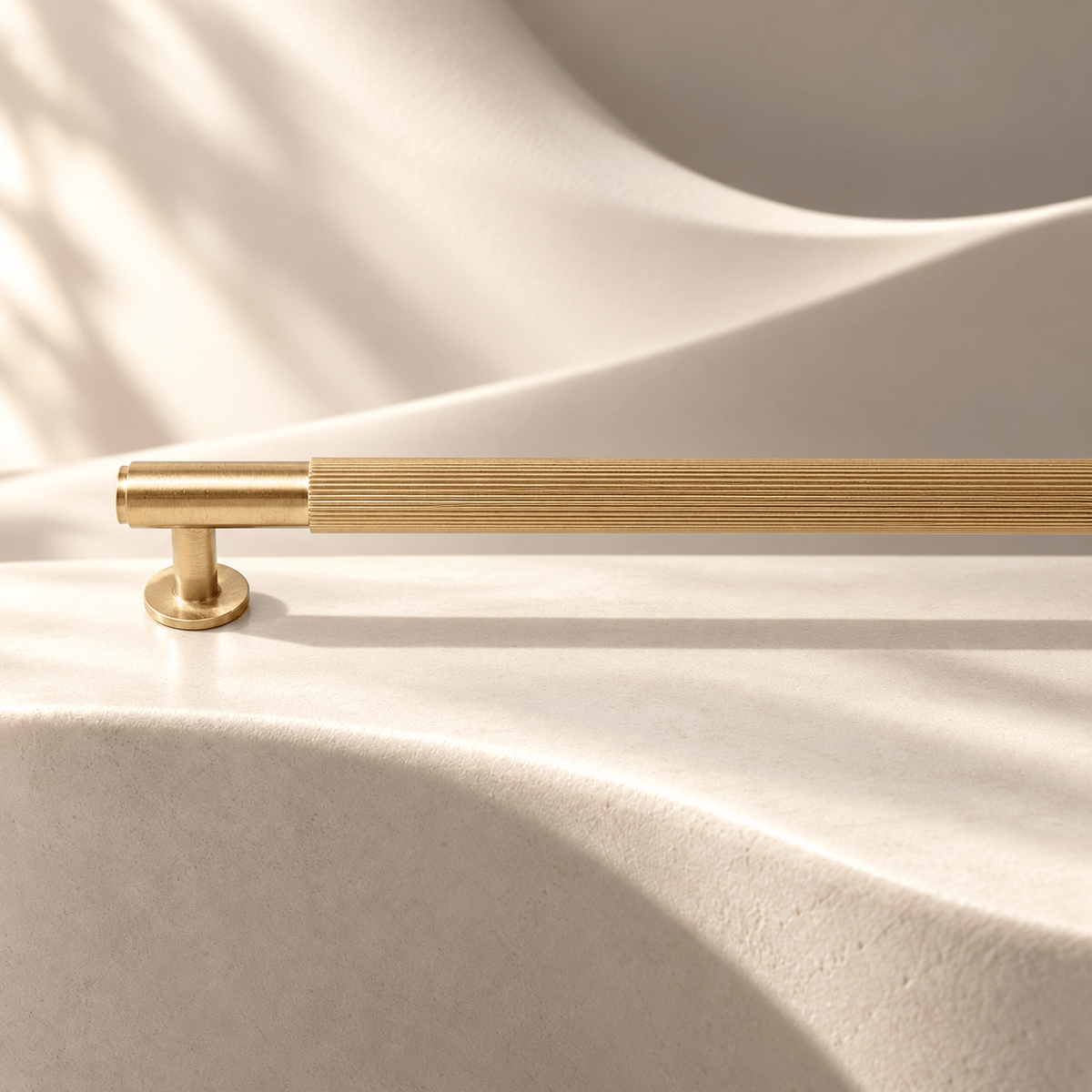 Gold straight-fluted 320 mm center-to-center cabinet pull on warm ivory stone
