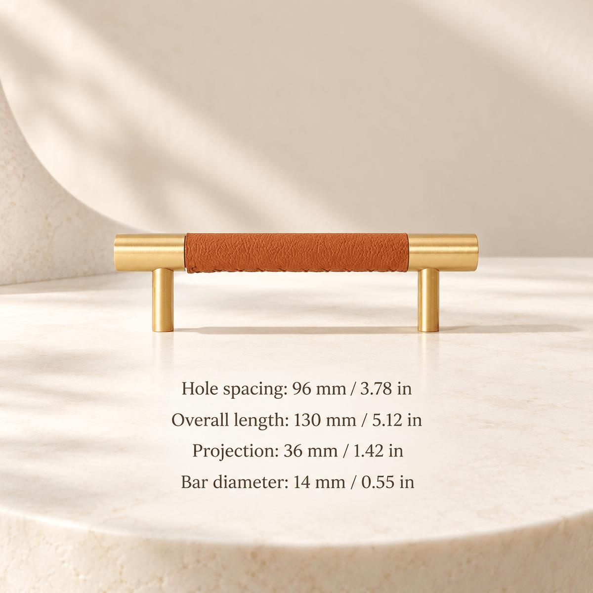 Tan leather and gold cabinet pull in ivory studio. Hole spacing: 96 mm / 3.78 in; Overall length: 130 mm / 5.12 in; Projection: 36 mm / 1.42 in; Bar diameter: 14 mm / 0.55 in