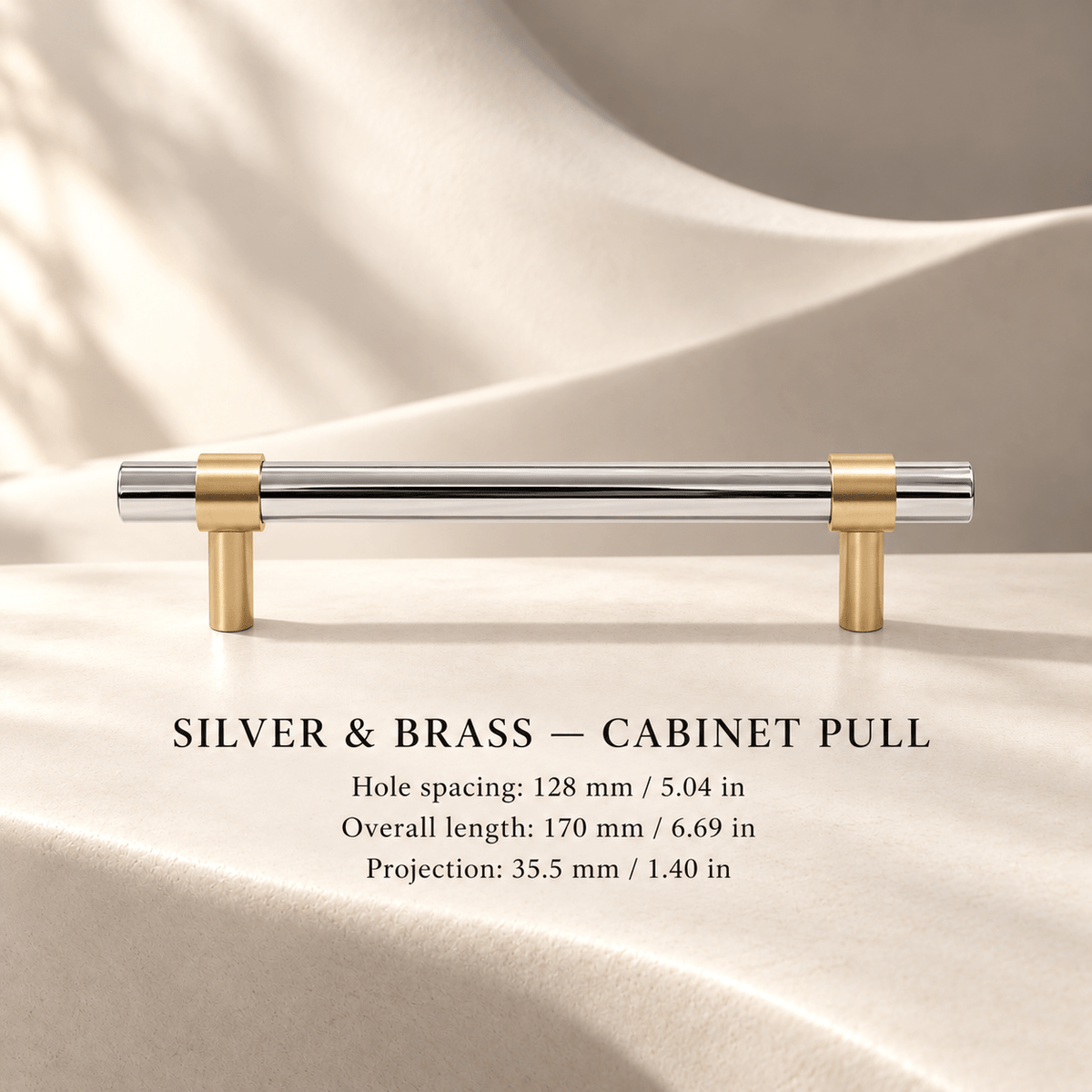 Silver steel and brass cabinet pull in ivory studio. Hole spacing: 128 mm / 5.04 in; Overall length: 170 mm / 6.69 in; Projection: 35.5 mm / 1.40 in