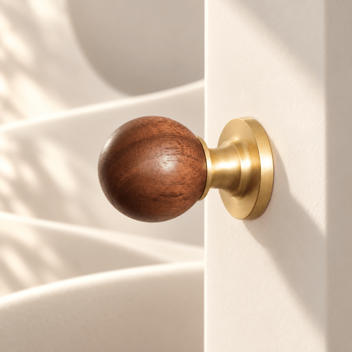 Walnut round knob with satin gold-tone base in warm ivory sunlight studio