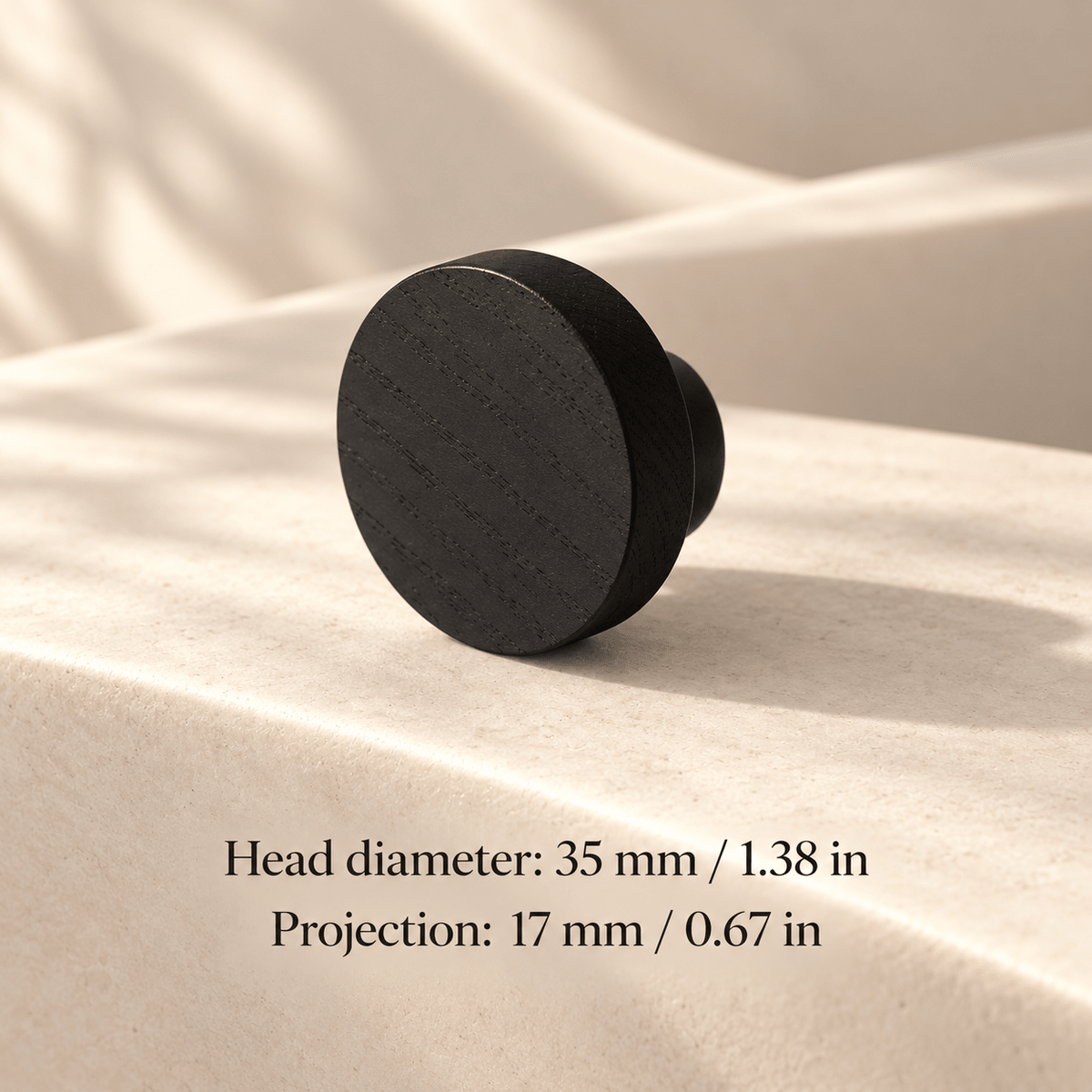 black cabinet knob in ivory studio. Head diameter: 35 mm / 1.38 in; Projection: 17 mm / 0.67 in